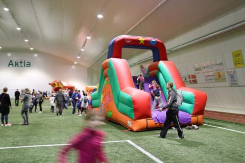 Hoppslott med många människor på en konstgräsplan